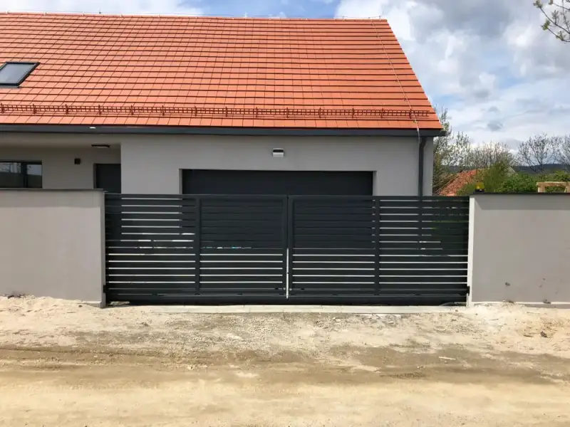 Brama wjazdowa i ogrodzenie przed domem z garażem