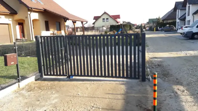 Brama z pionowych profili zamykająca wjazd na posesję
