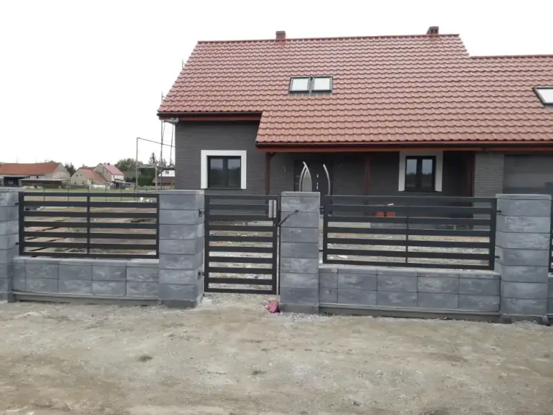 Dom jednorodzinny z nowym ogrodzeniem palisadowym na podmurówce