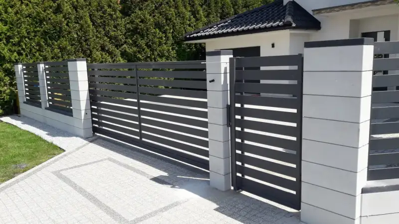 Palisada pozioma na jasnej podmurówce z bloczków – realizacja przy domu jednorodzinnym