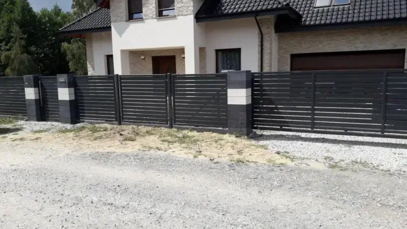 Ogrodzenie palisadowe z furtką osadzoną między słupkami z bloczków